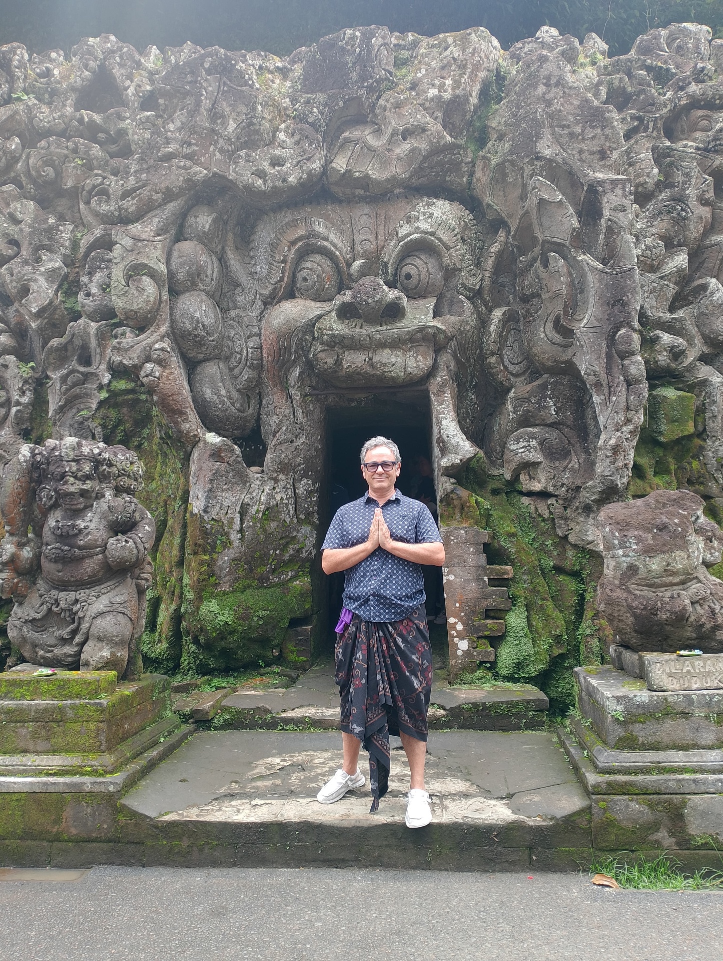 Prayer mudra at the entrance to Goa Gajah — the Elephant Cave