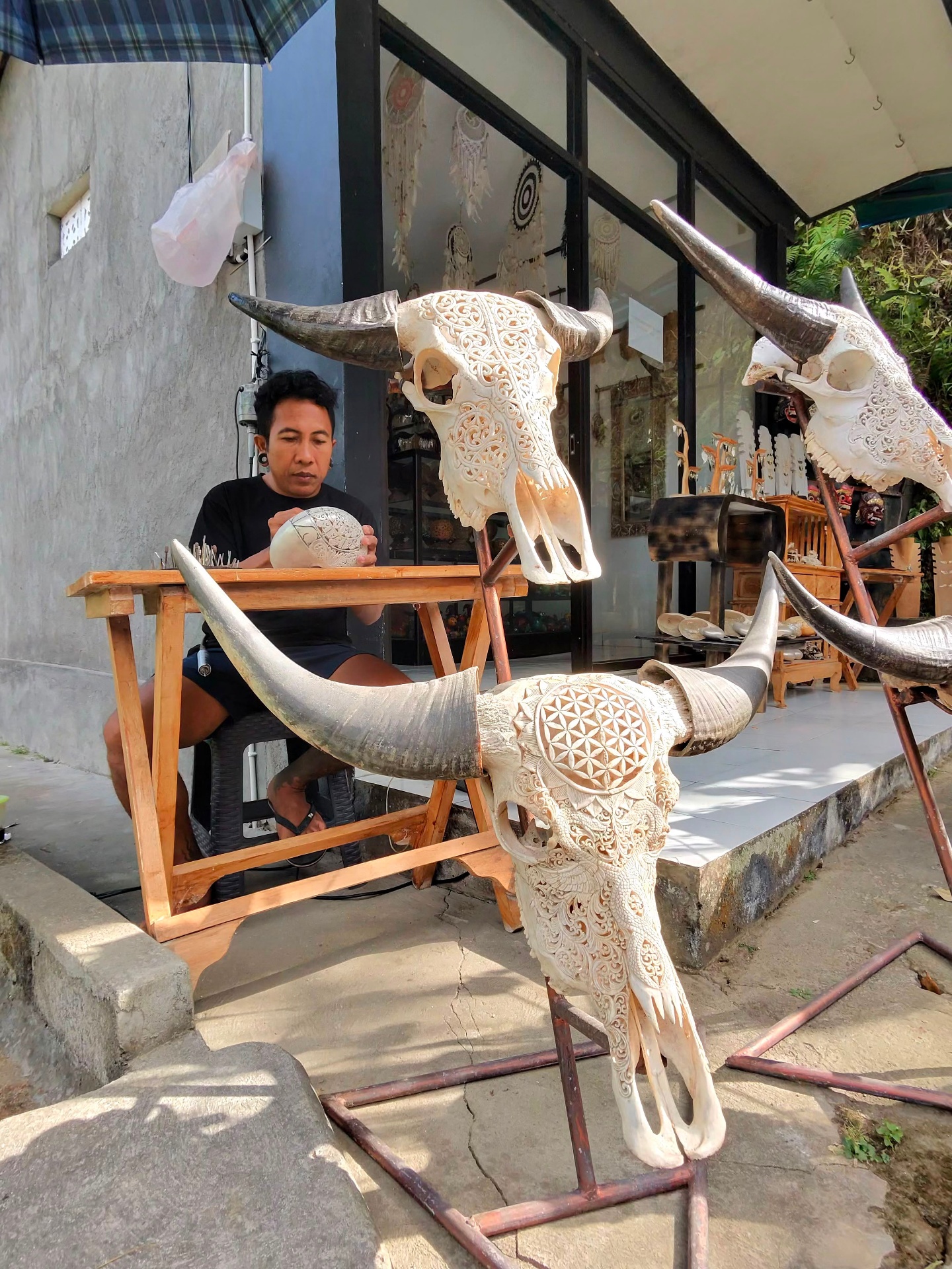 Balinese craftsman carving a buffalo skull with sacred geometry